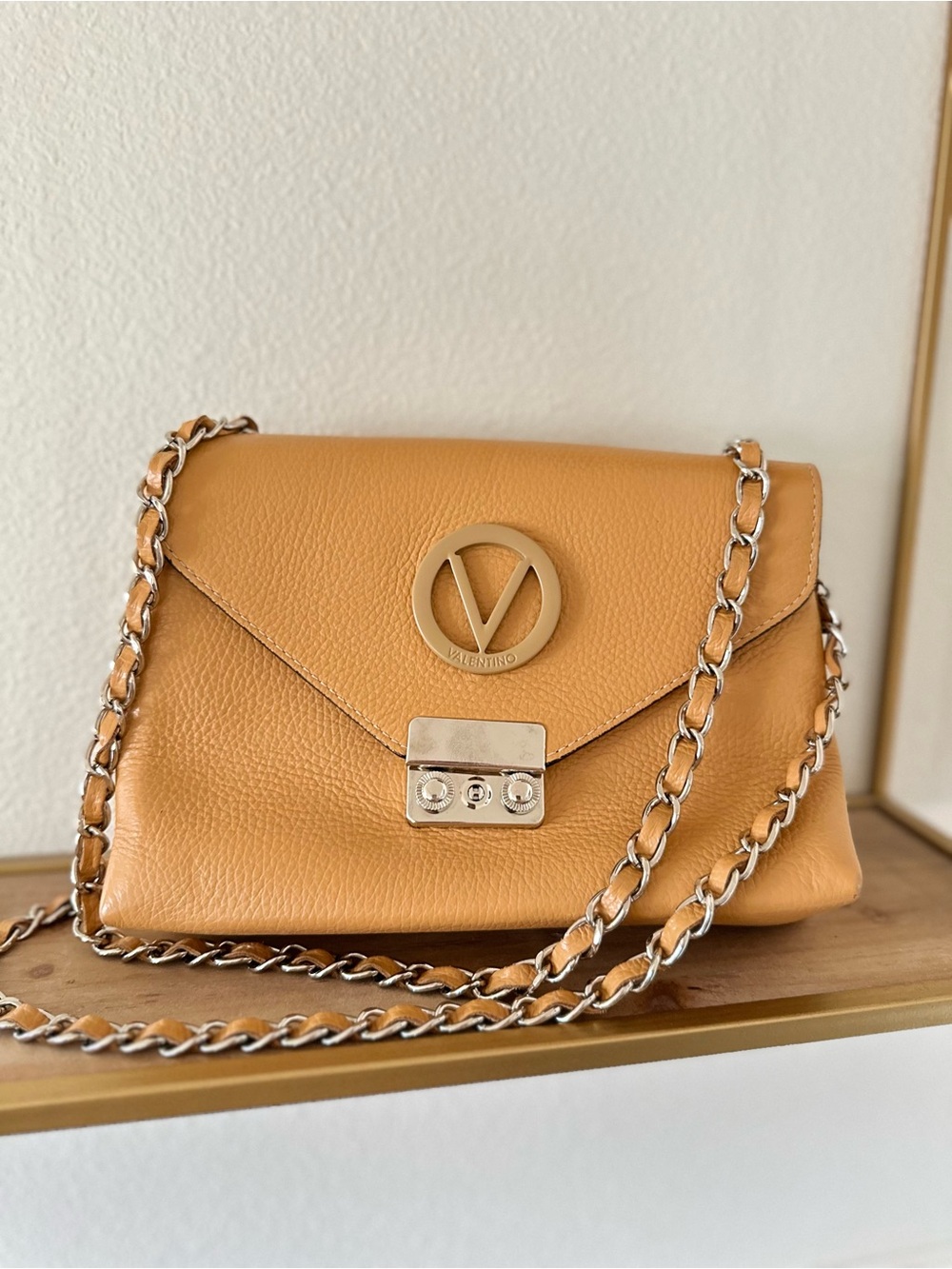 Valentino tan/carmel leather chain crossbody bag with V logo.